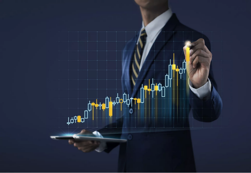 A person in a suit analyzes a digital financial chart with a tablet and a stylus.