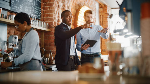 Business owners discussing strategies in a coffee shop after a slow Small Business Saturday.