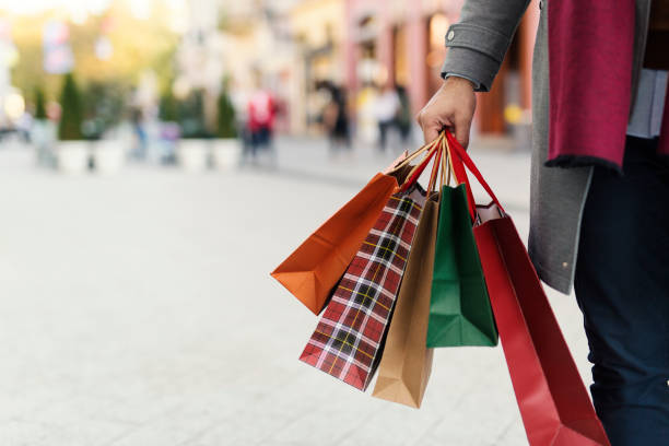 A person holds multiple colorful shopping bags, suggesting successful holiday business strategies.